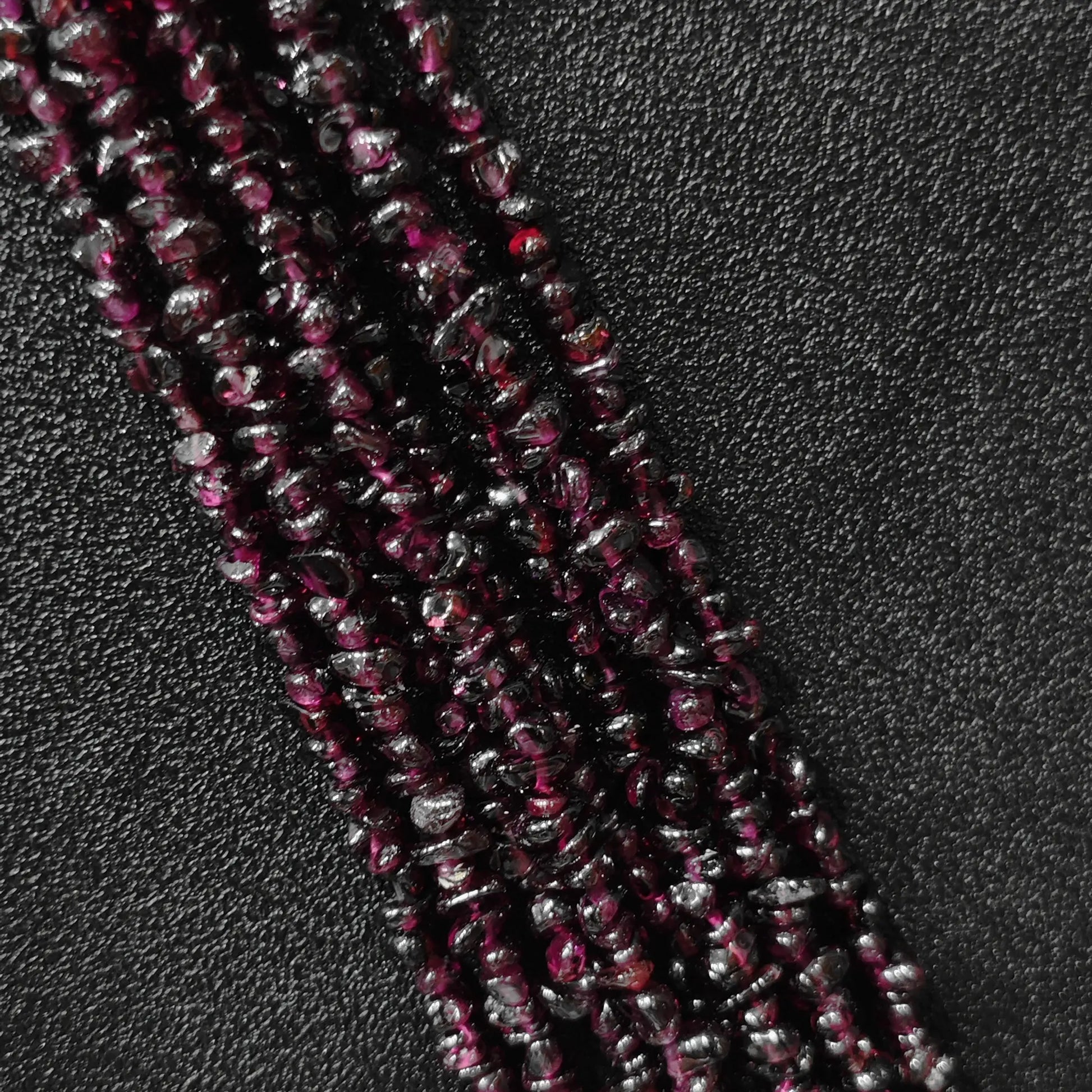 Macro closeup of natural wine red garnet freeform chip beads showing deep red tones