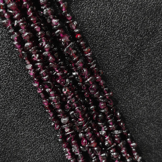 Macro closeup of natural wine red garnet freeform chip beads showing deep red tones