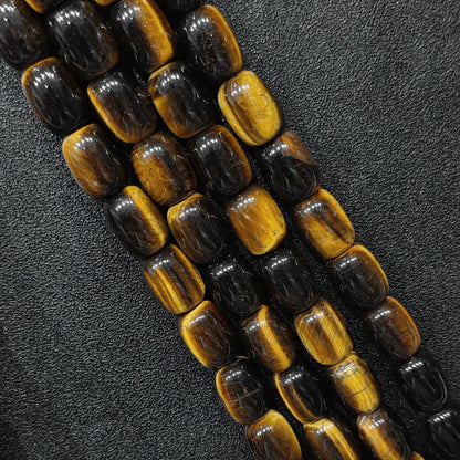 Macro closeup of natural yellow tigers eye barrel beads showing golden chatoyant bands