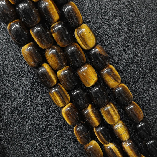 Macro closeup of natural yellow tigers eye barrel beads showing golden chatoyant bands
