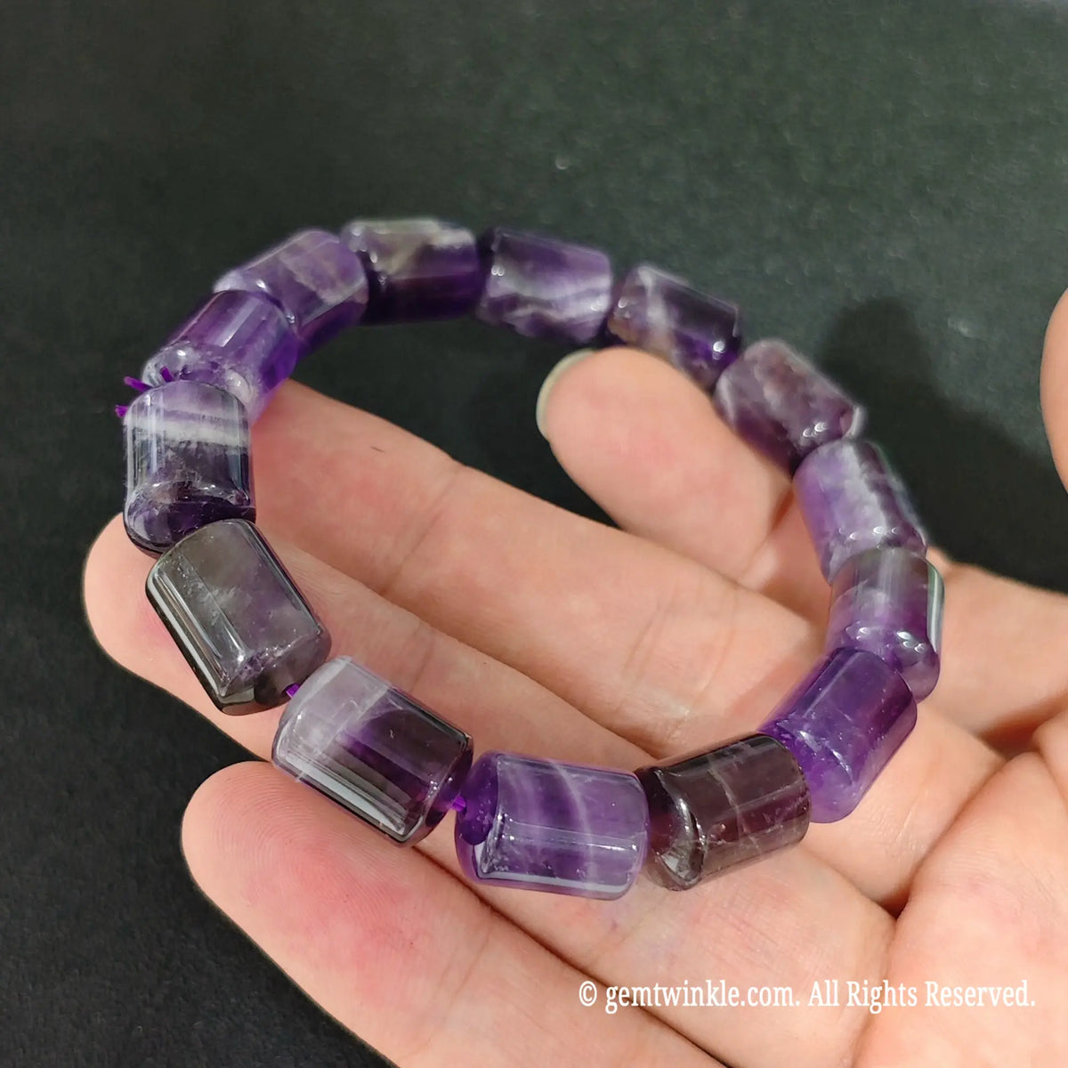 close up view of 14x10mm purple amethyst drum beads showing natural quartz color zoning