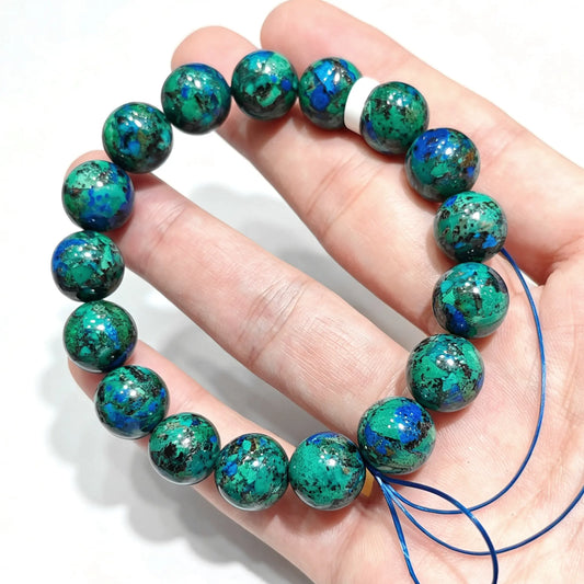 natural azurite malachite round bead bracelet held across hand showing deep blue and green mineral patterns