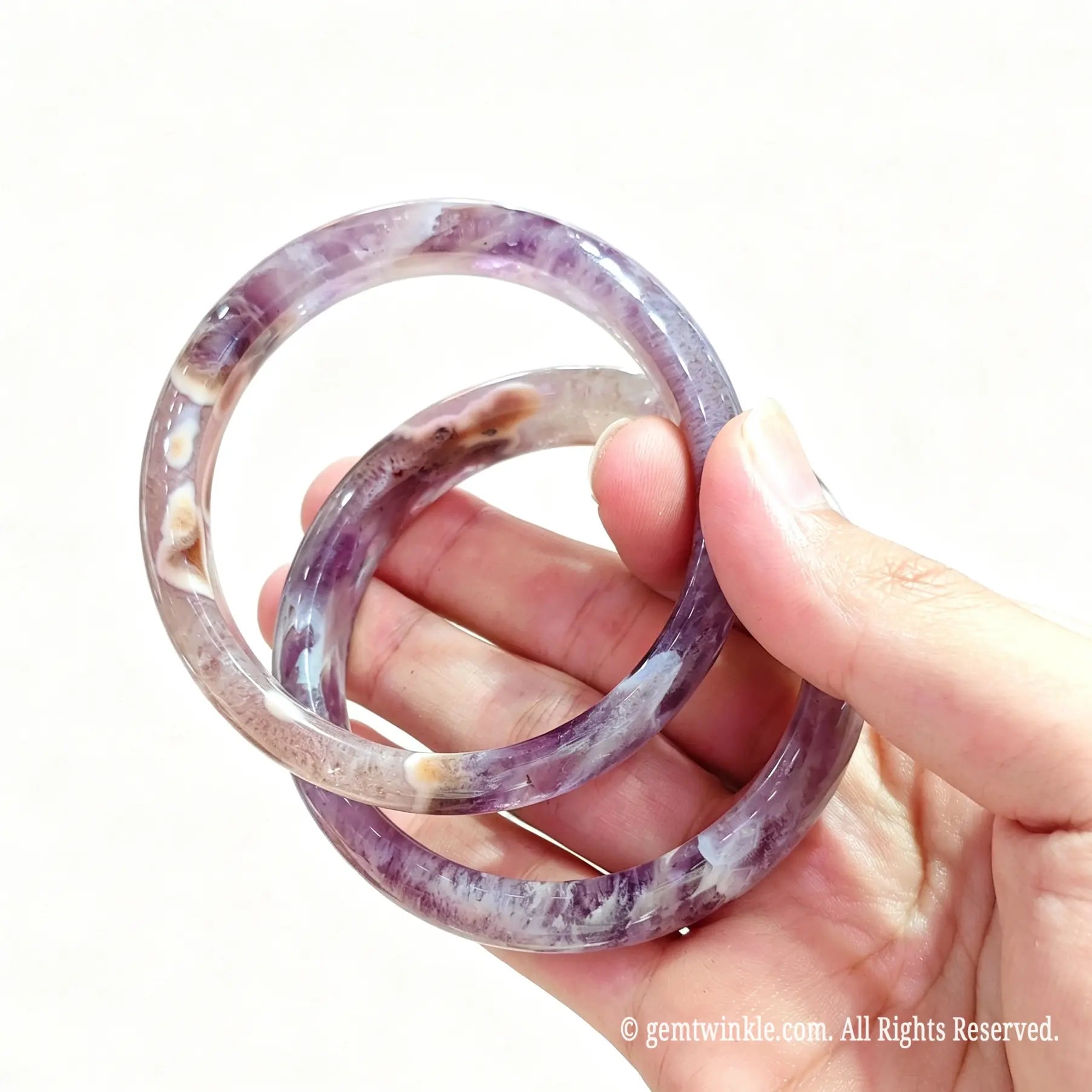 Two natural amethyst agate bangles held together highlighting rich violet color and organic lace banding