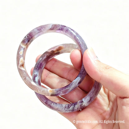 Two natural amethyst agate bangles held together highlighting rich violet color and organic lace banding
