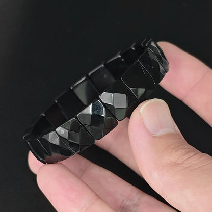 Natural black obsidian 12mm diamond faceted square bead bracelet held in hand showing geometric light reflections