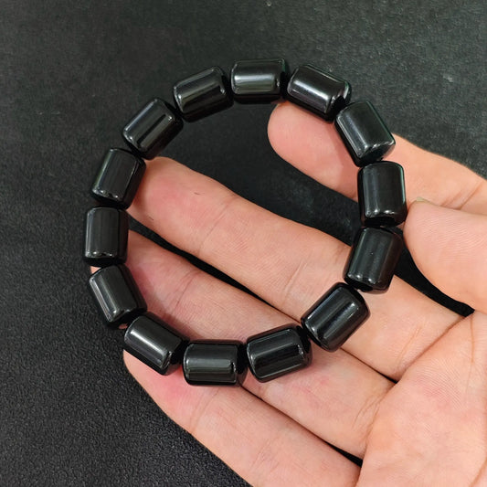 natural black obsidian 14x10mm barrel bead gemstone bracelet held in hand showing glossy surface
