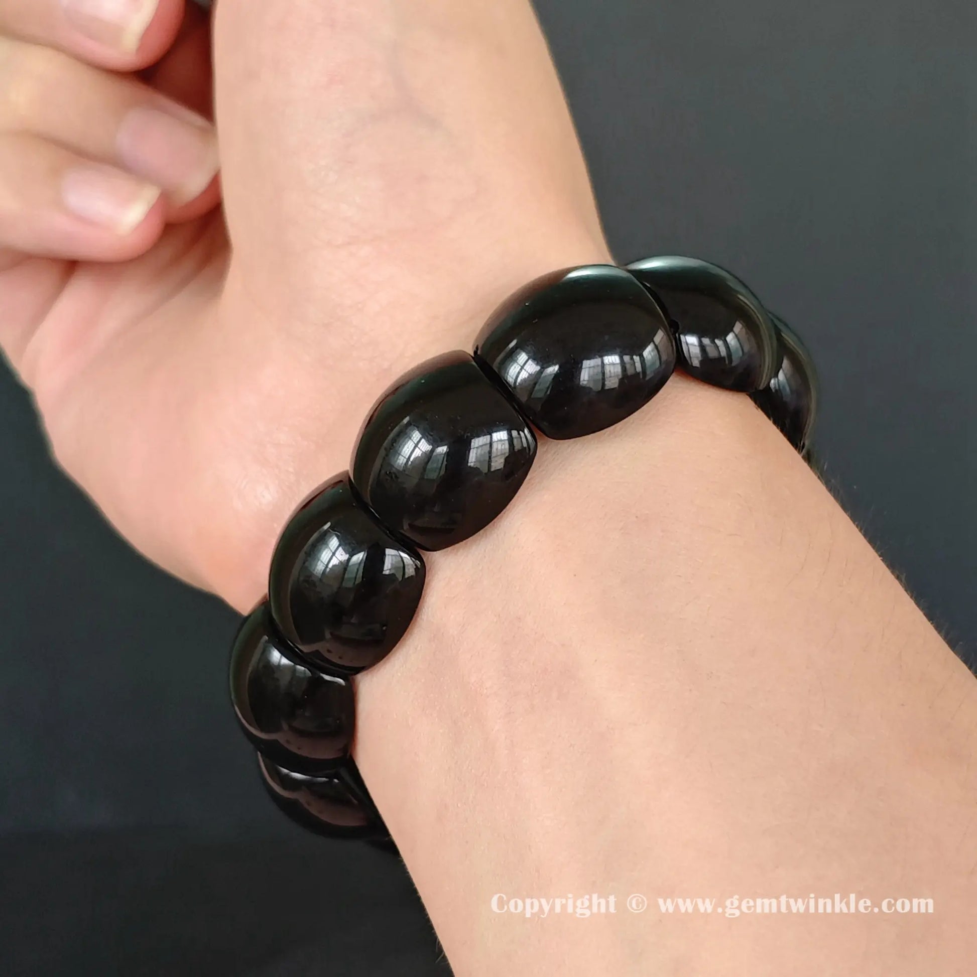 black obsidian plate cuff bracelet on wrist showing 18cm fit and smooth curved geometric beads