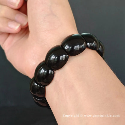 black obsidian plate cuff bracelet on wrist showing 18cm fit and smooth curved geometric beads