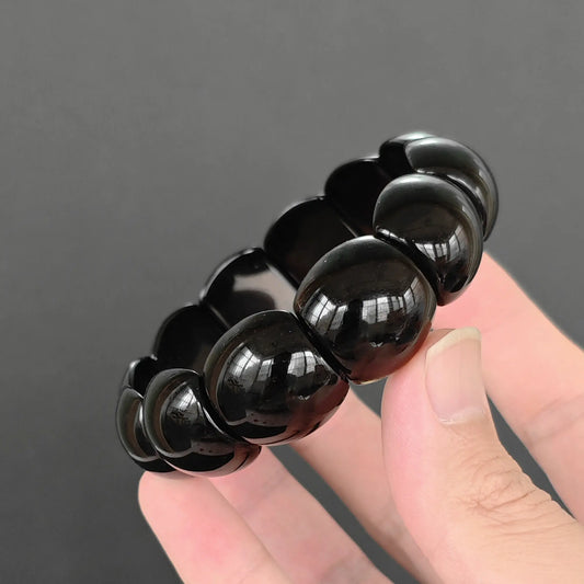 natural black obsidian plate cuff bracelet featuring 22x17mm chunky glossy beads held in hand