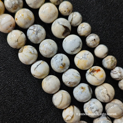 natural blue opal matrix loose bead strands from seven millimeter to twelve millimeter sizes arranged on black leather surface
