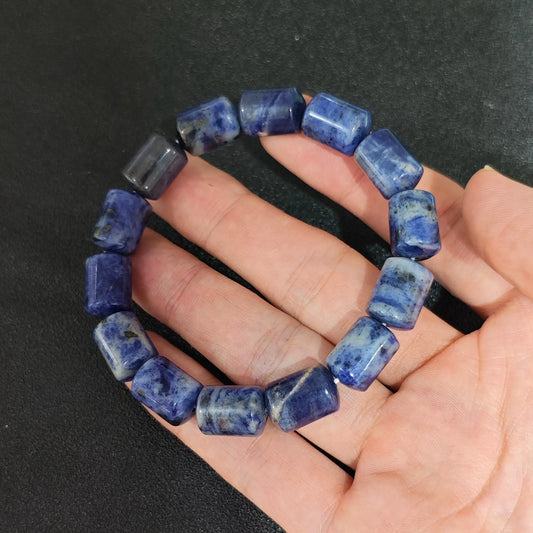 natural blue sodalite 14x10mm barrel bead gemstone bracelet held in hand showing white calcite veining