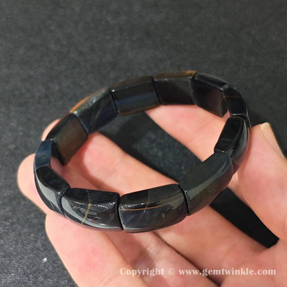 blue tigers eye plate stretch bracelet showcasing smooth glossy texture and subtle yellow mineral veins