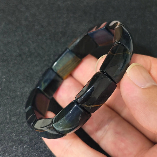 natural blue tigers eye plate cuff bracelet featuring 16mm curved beads held in hand with natural golden accents