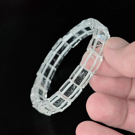 Natural clear quartz 10mm pyramid faceted square bead bracelet held in hand showing 3D geometric pyramid facets