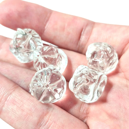 Natural clear quartz lion beads 15mm held in hand showing top-to-bottom vertical drill holes and carved lion details