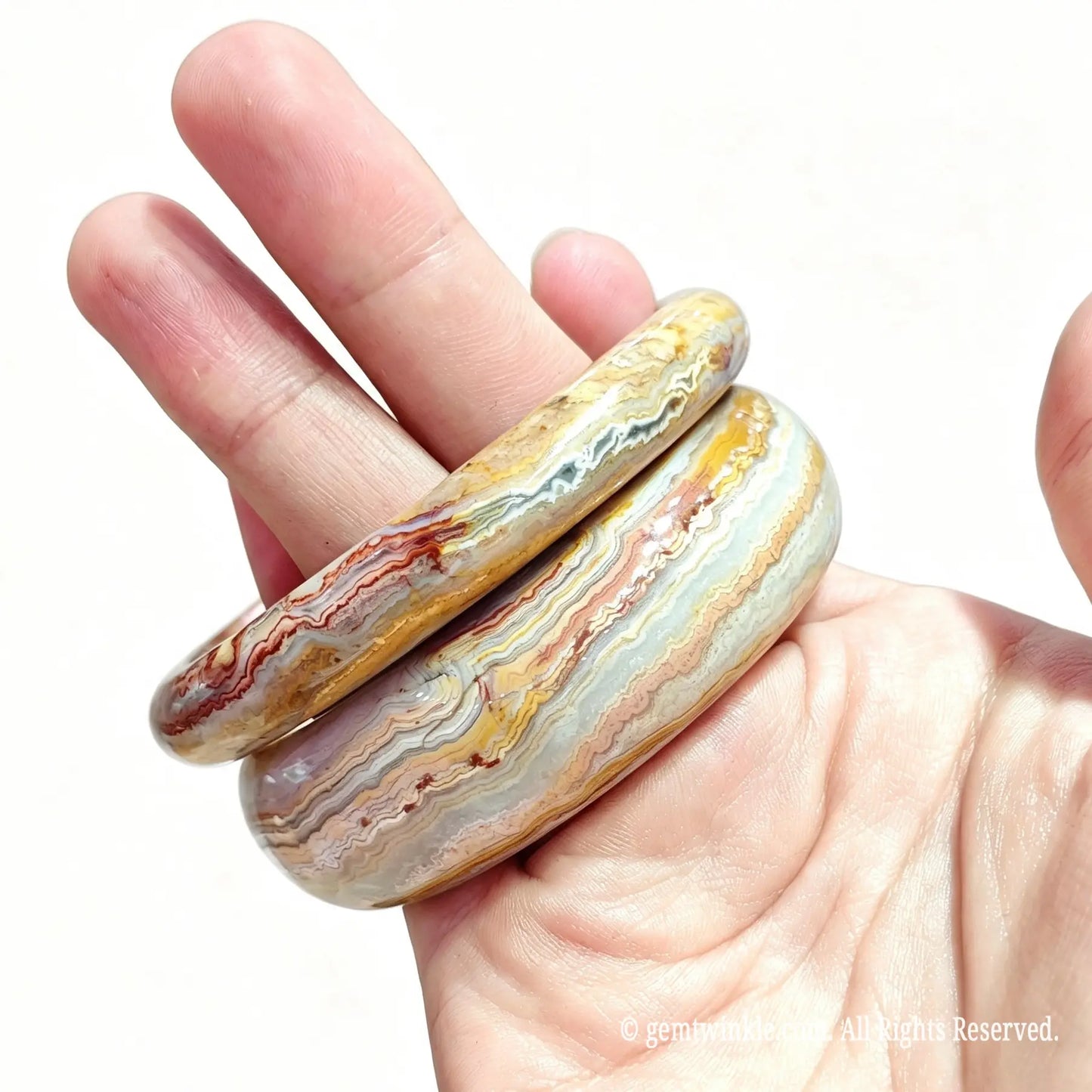 Close up view of natural crazy lace agate bangles displaying dynamic fortification lines