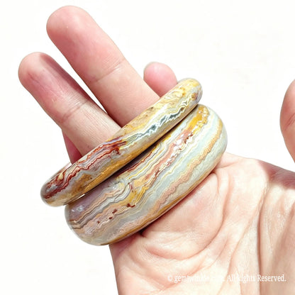 Close up view of natural crazy lace agate bangles displaying dynamic fortification lines