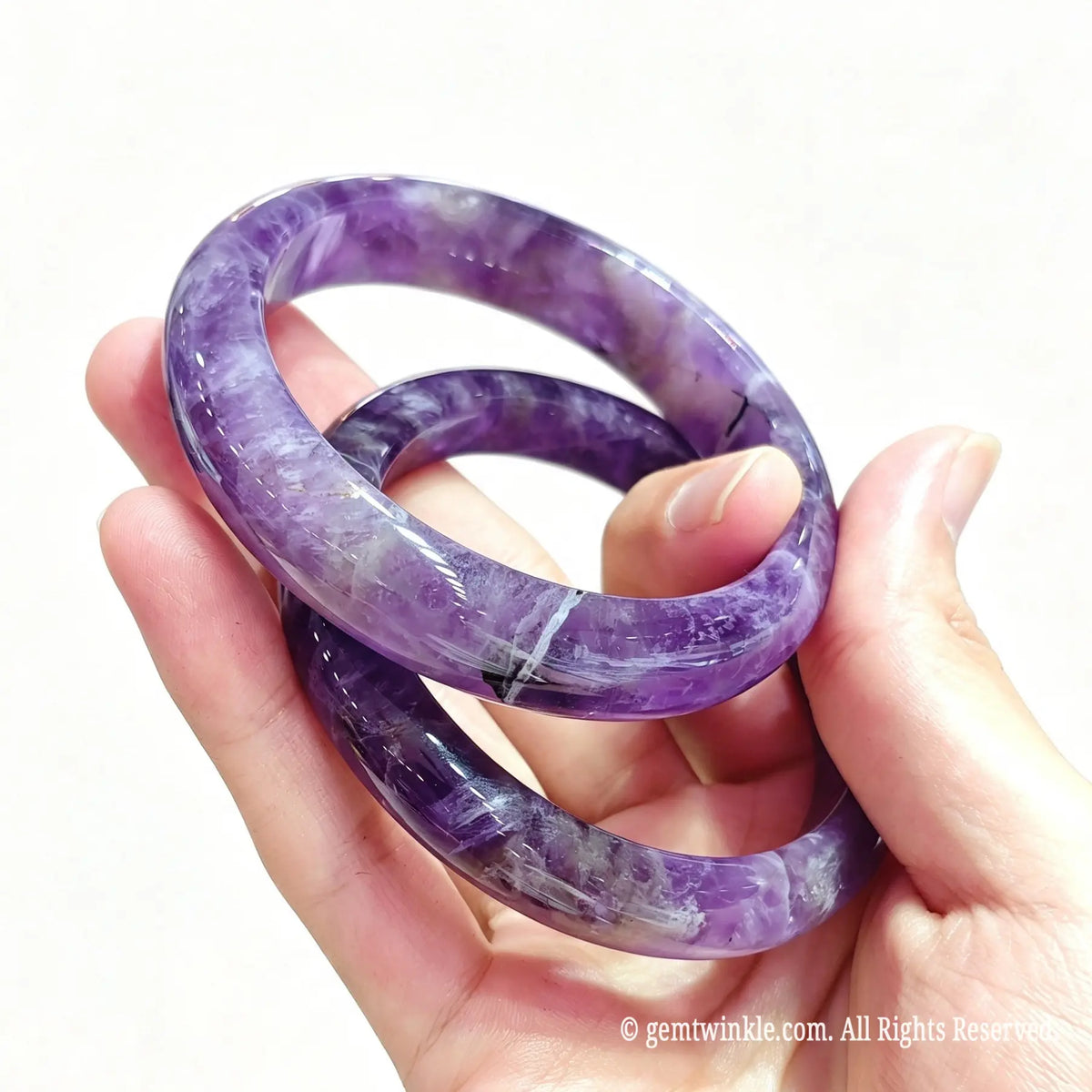 Top view of natural dream amethyst bangles held together showcasing unique V-shaped white quartz patterns