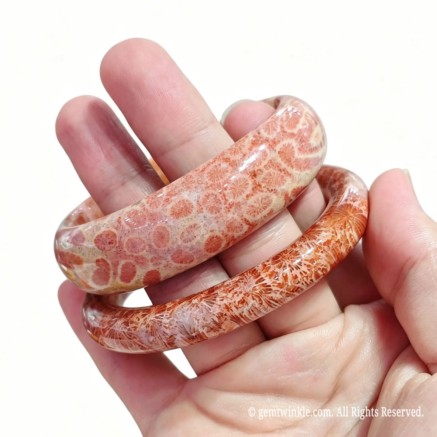 Angled view of two natural fossil coral agate bangles held together for boutique inventory selection