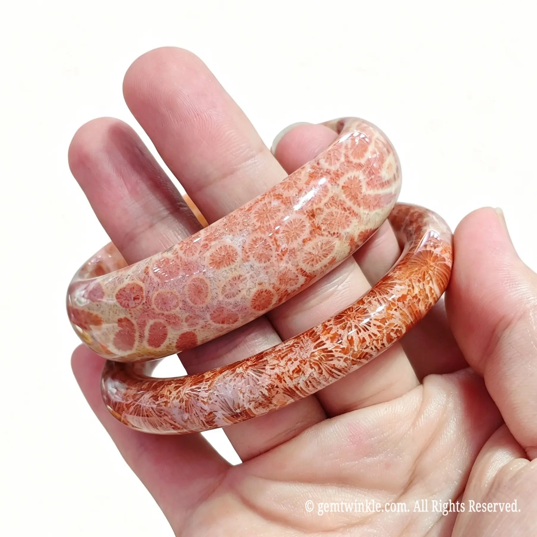 Angled view of two natural fossil coral agate bangles held together for boutique inventory selection