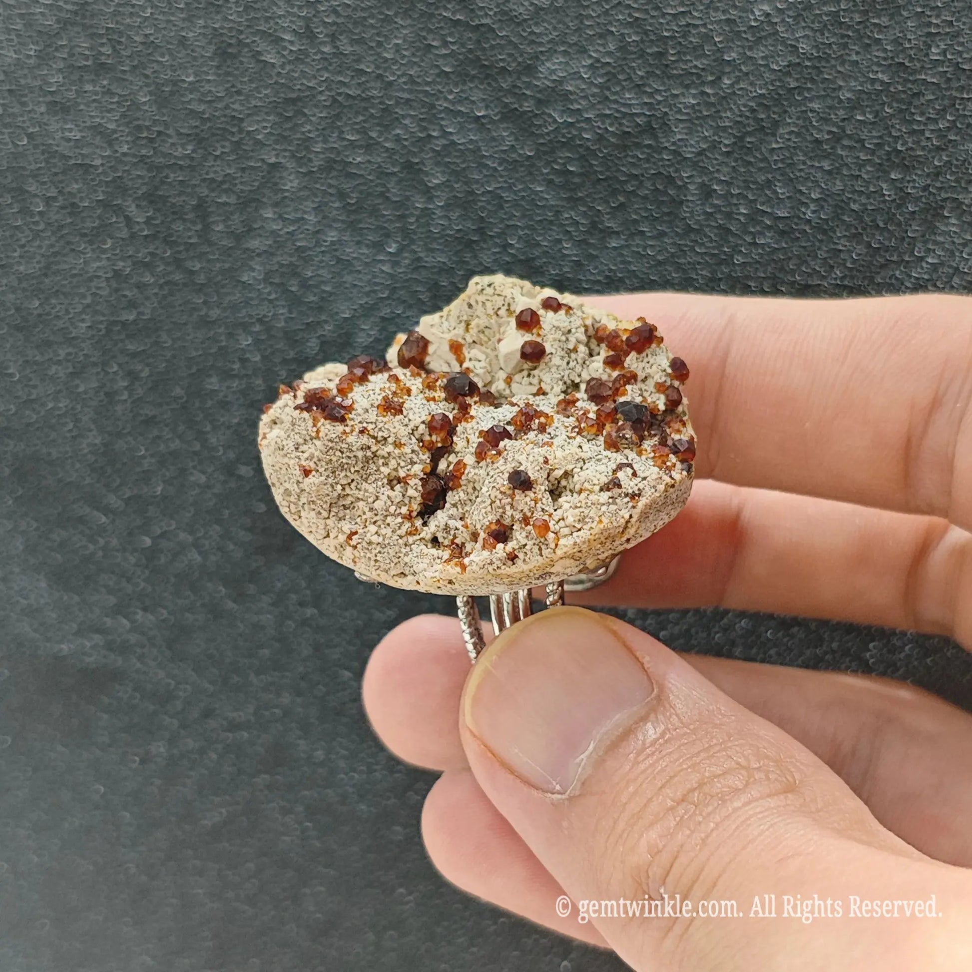 Natural garnet matrix specimen ring side view held in hand showing organic stone thickness and alloy band