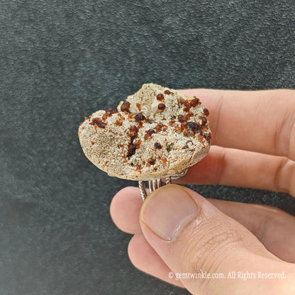 Natural garnet matrix specimen ring side view held in hand showing organic stone thickness and alloy band
