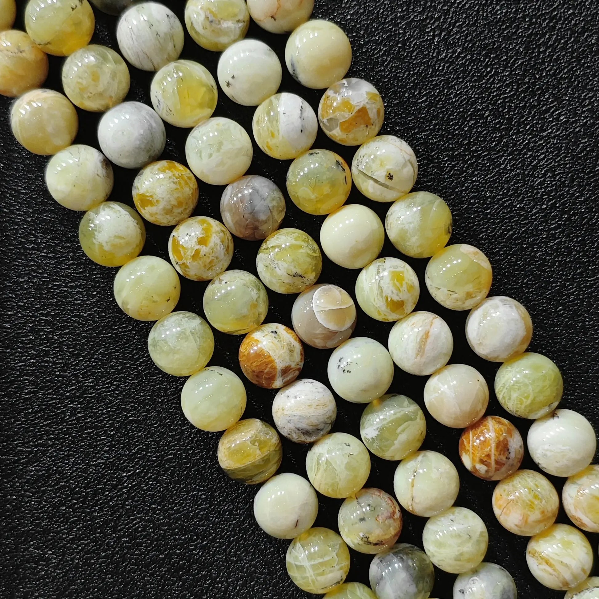 natural gemstone beads for jewelry making featuring genuine yellow opal matrix loose strands from 8mm to 10mm sizes on black background