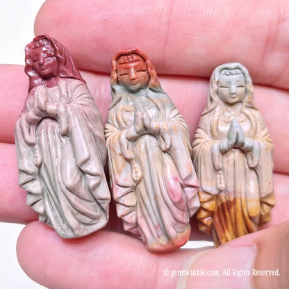 Three hand-carved Alashan agate Virgin Mary statues held in hand displaying natural color variations