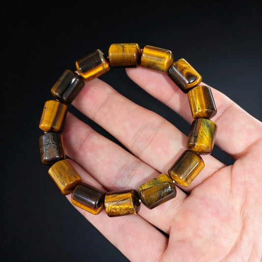 close up of 14x10mm yellow tiger eye drum beads displaying golden optical bands and silk luster