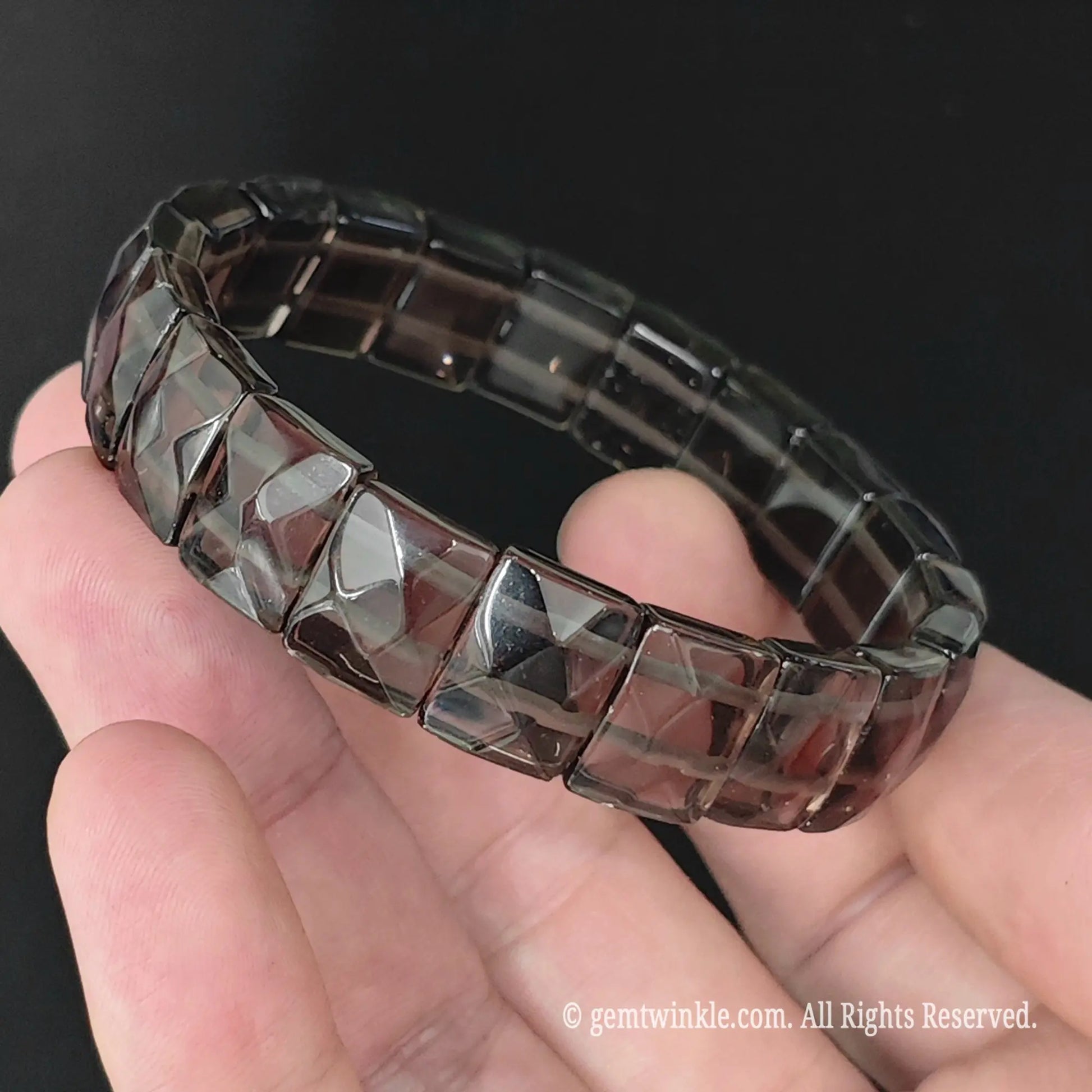 Natural ice obsidian square bead pyramid cuff bracelet displayed in hand showing clear volcanic glass structure