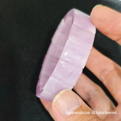 close up view of 15x11mm pink kunzite segments showing fibrous mineral striations and silky vitreous luster