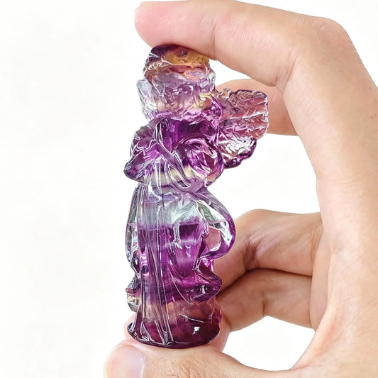 natural light rainbow fluorite praying angel statue displaying translucent magenta purple and mint green color bands
