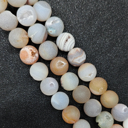 Close up view of natural matte druzy agate geode loose beads in 12mm diameter showing exposed caves with tiny quartz crystal clusters wholesale sourcing