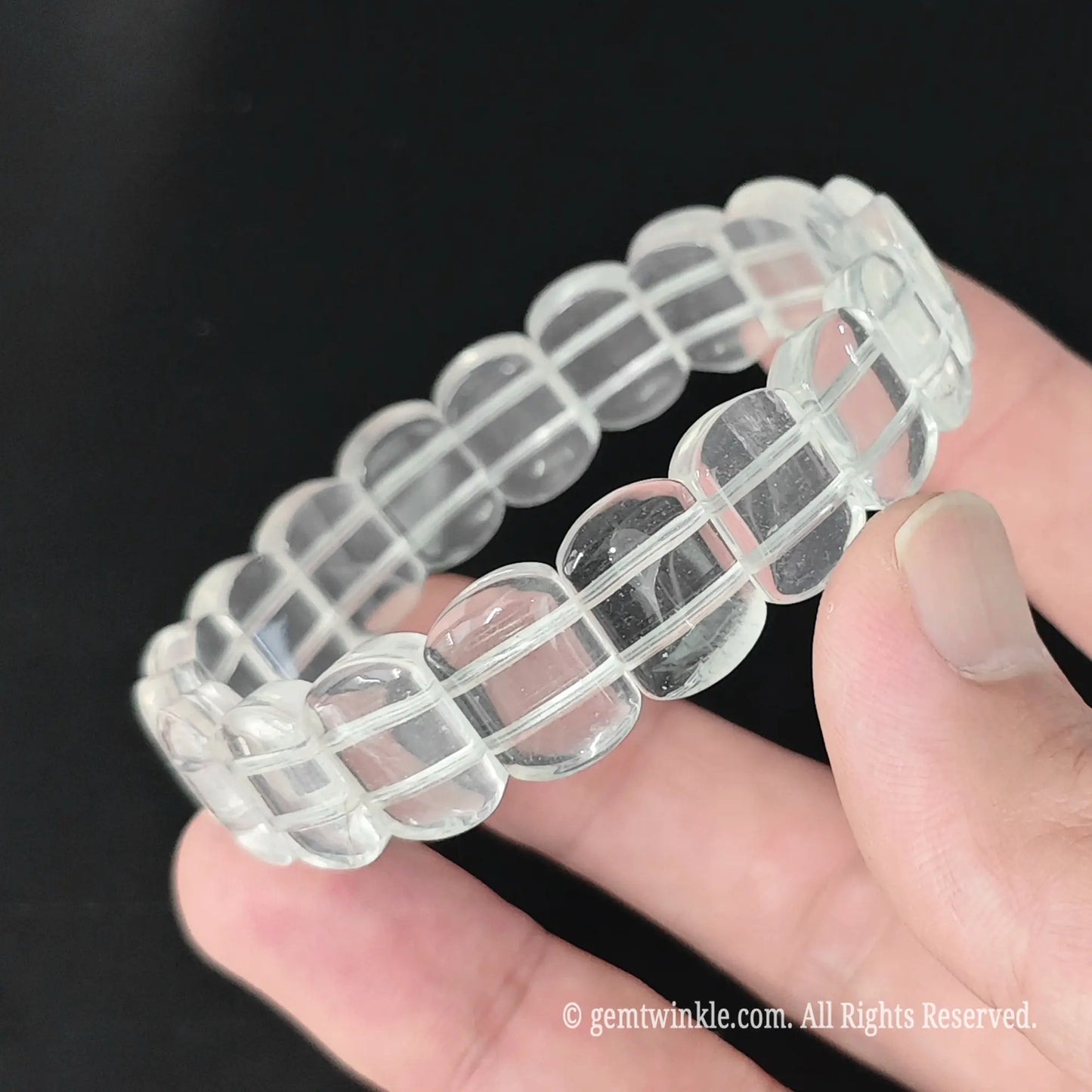 Full view of natural milky quartz 14mm smooth block bead bracelet resting in hand with gentle light reflections