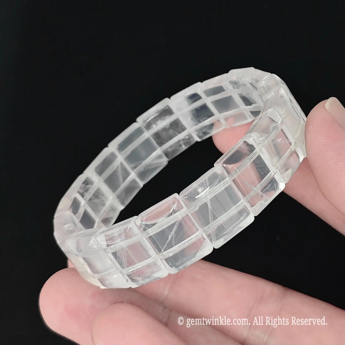 Full view of natural milky quartz 15mm smooth block bead bracelet resting in hand with bright light reflection