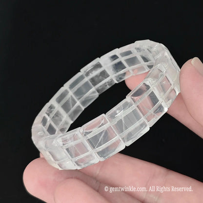 Full view of natural milky quartz 15mm smooth block bead bracelet resting in hand with bright light reflection
