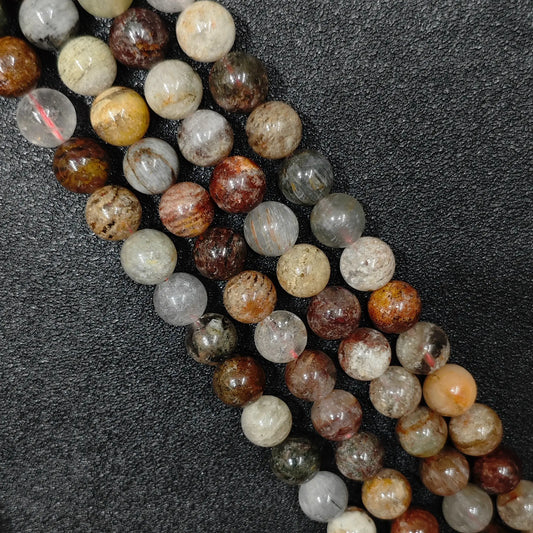 close look at 10mm natural multi color phantom quartz gemstone strands with rich scenic lodolite inclusions on black background