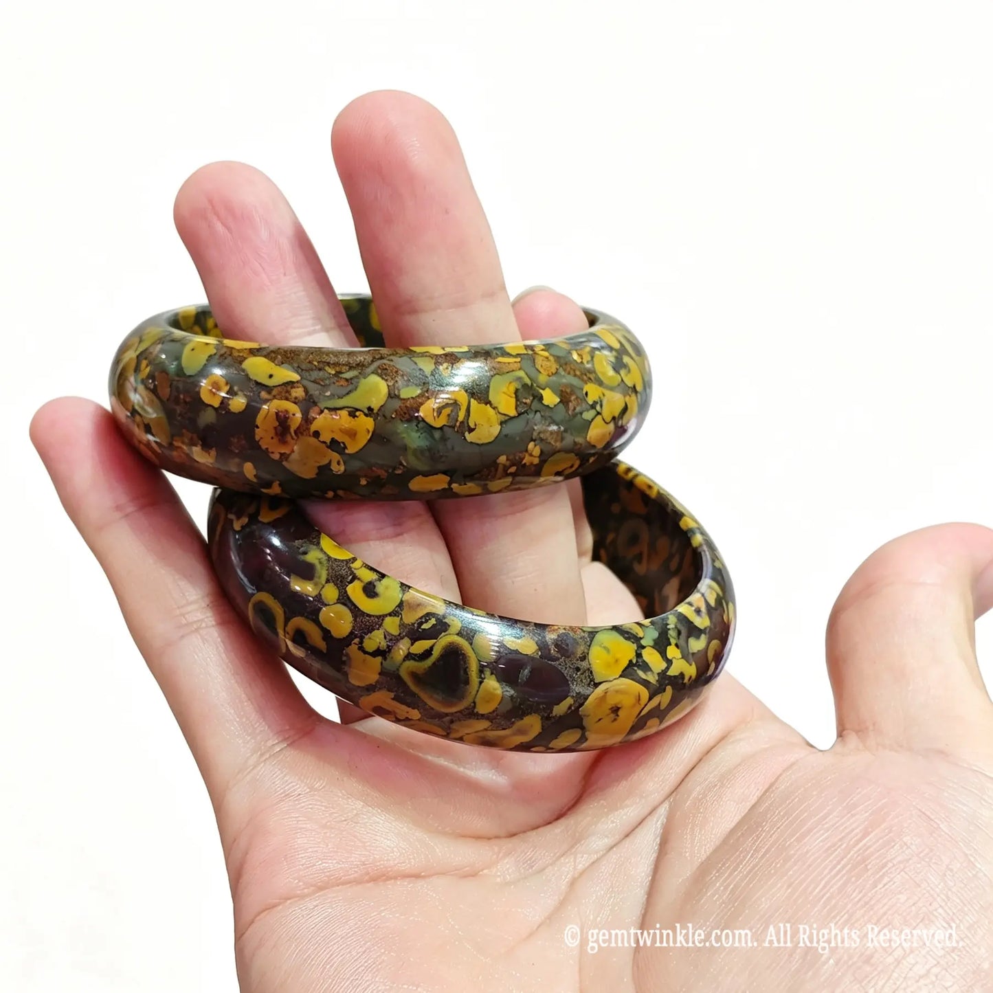 Side view of polished natural leopard jasper bangle displaying glossy finish and organic earth patterns