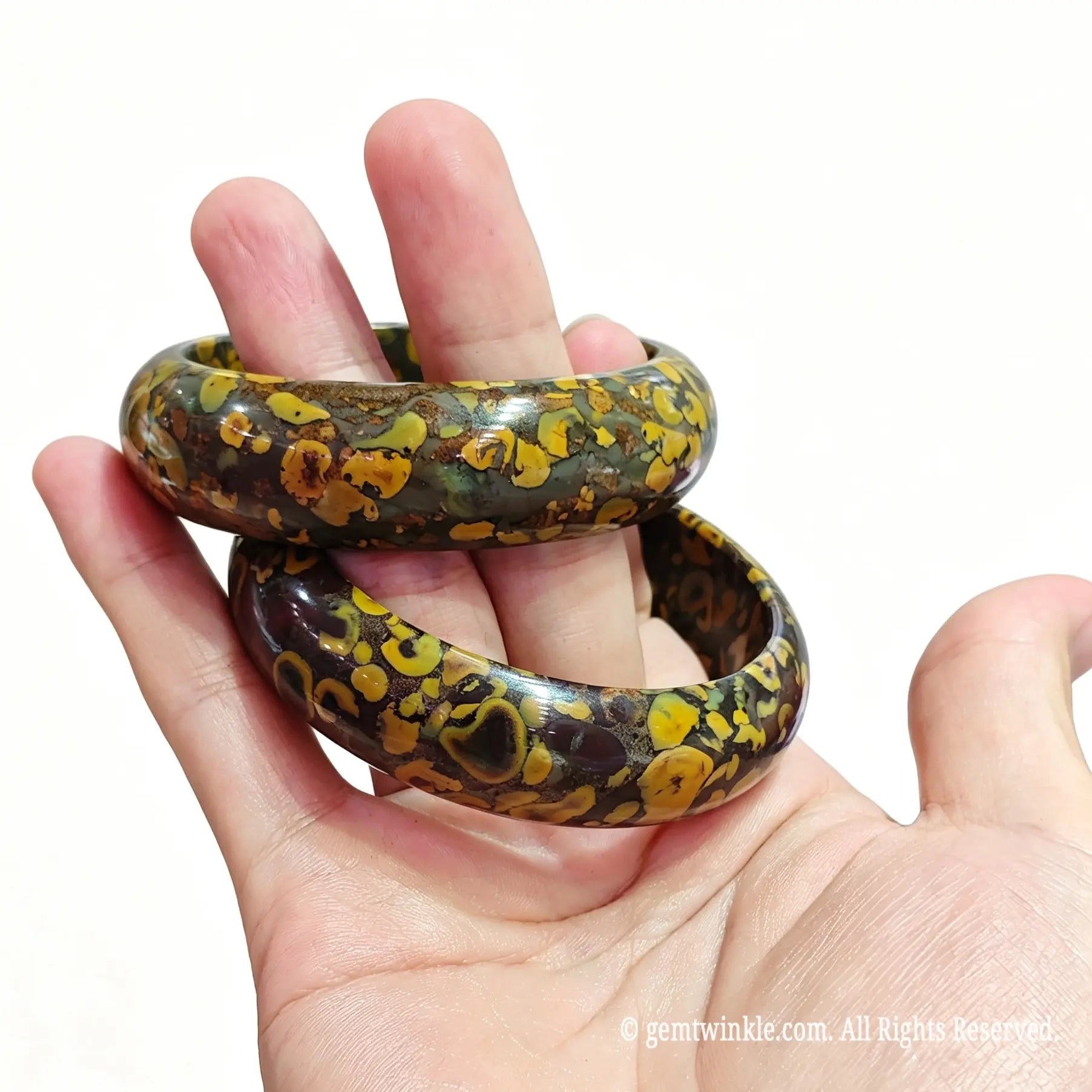 Side view of polished natural leopard jasper bangle displaying glossy finish and organic earth patterns