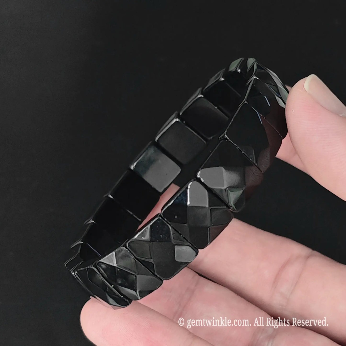 Side view of natural obsidian diamond cut geometric plate bracelet highlighting smooth faceted bead profile