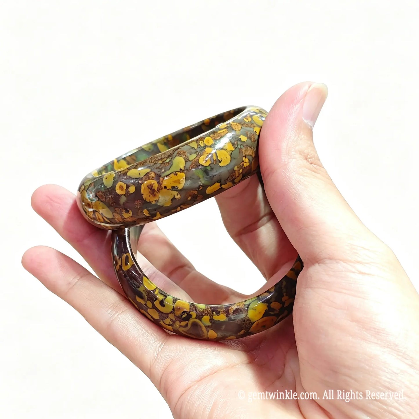 Two natural leopard skin jasper bangles held together highlighting golden yellow ringed inclusions