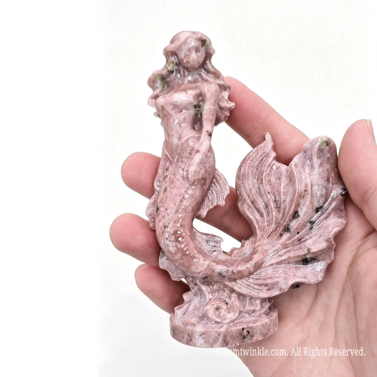 Single natural pink stone mermaid statue 11cm height held in hand showing detailed tail texture and figure profile