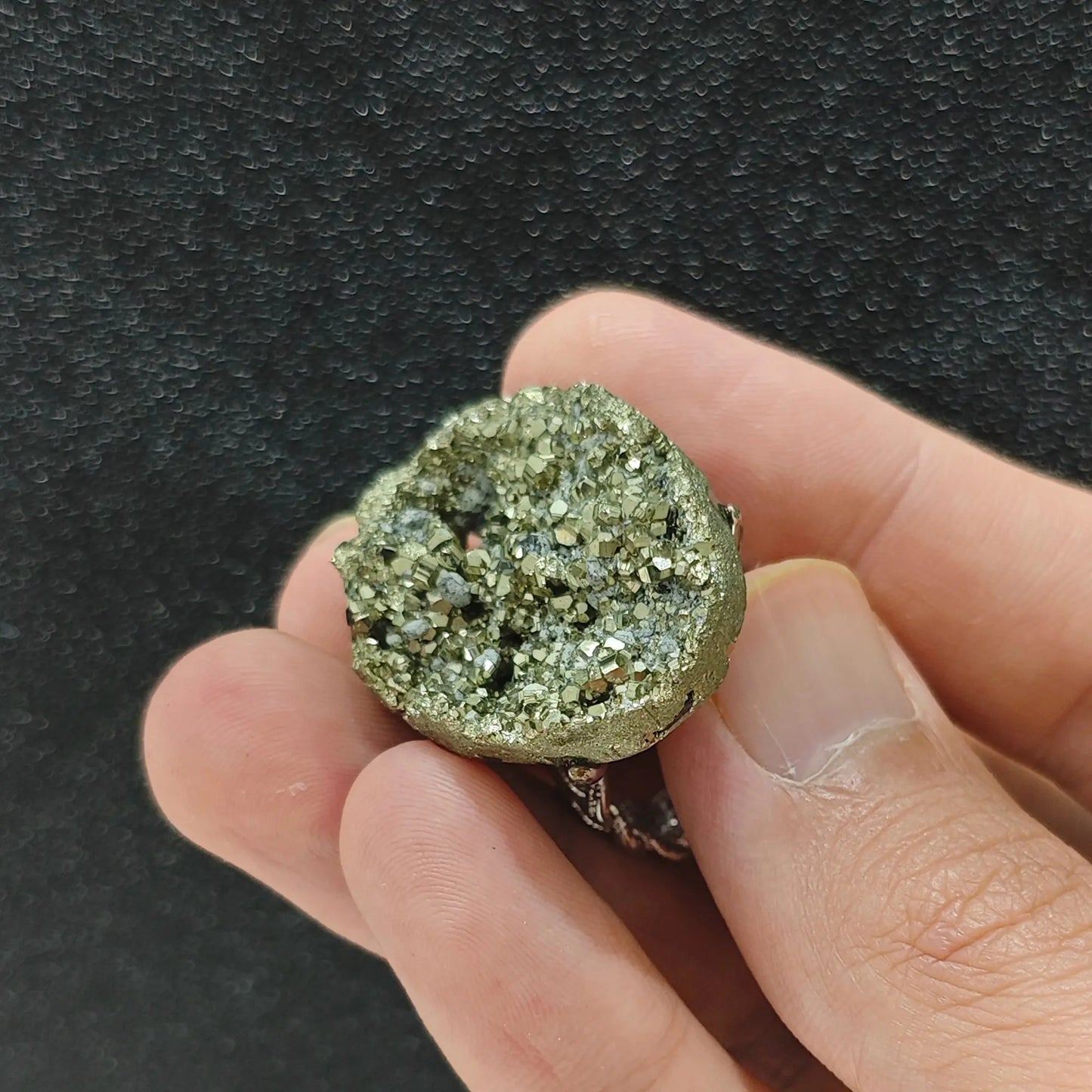 Natural pyrite crystal specimen ring side view held in hand showing organic raw stone height and filigree band