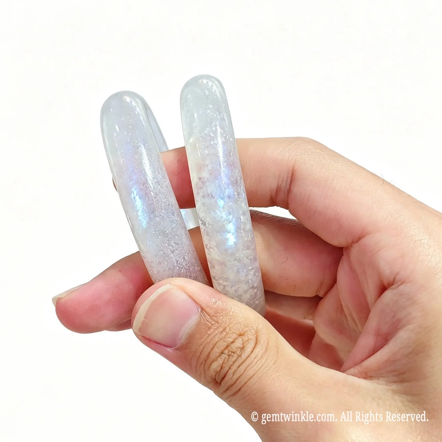 Two natural moonstone bangles held together displaying electric blue flash under light