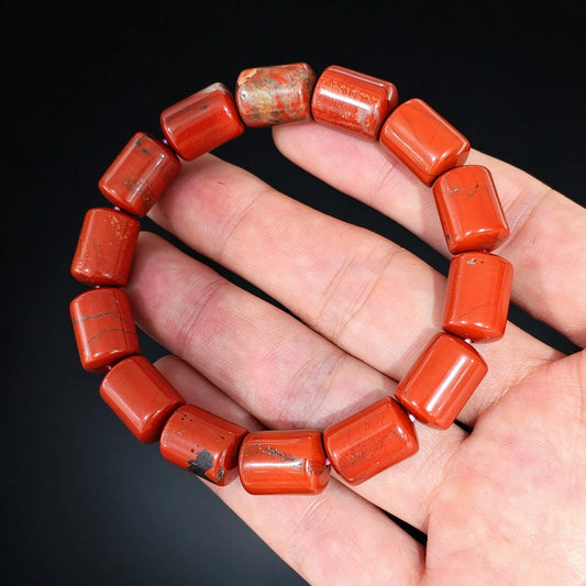 natural red jasper 14x10mm barrel bead bracelet held in hand showing rich brick red color