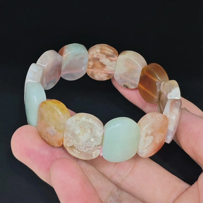 Natural sakura blossom agate 20x15mm smooth rectangular block bracelet held close up showing floral inclusions and glossy polish
