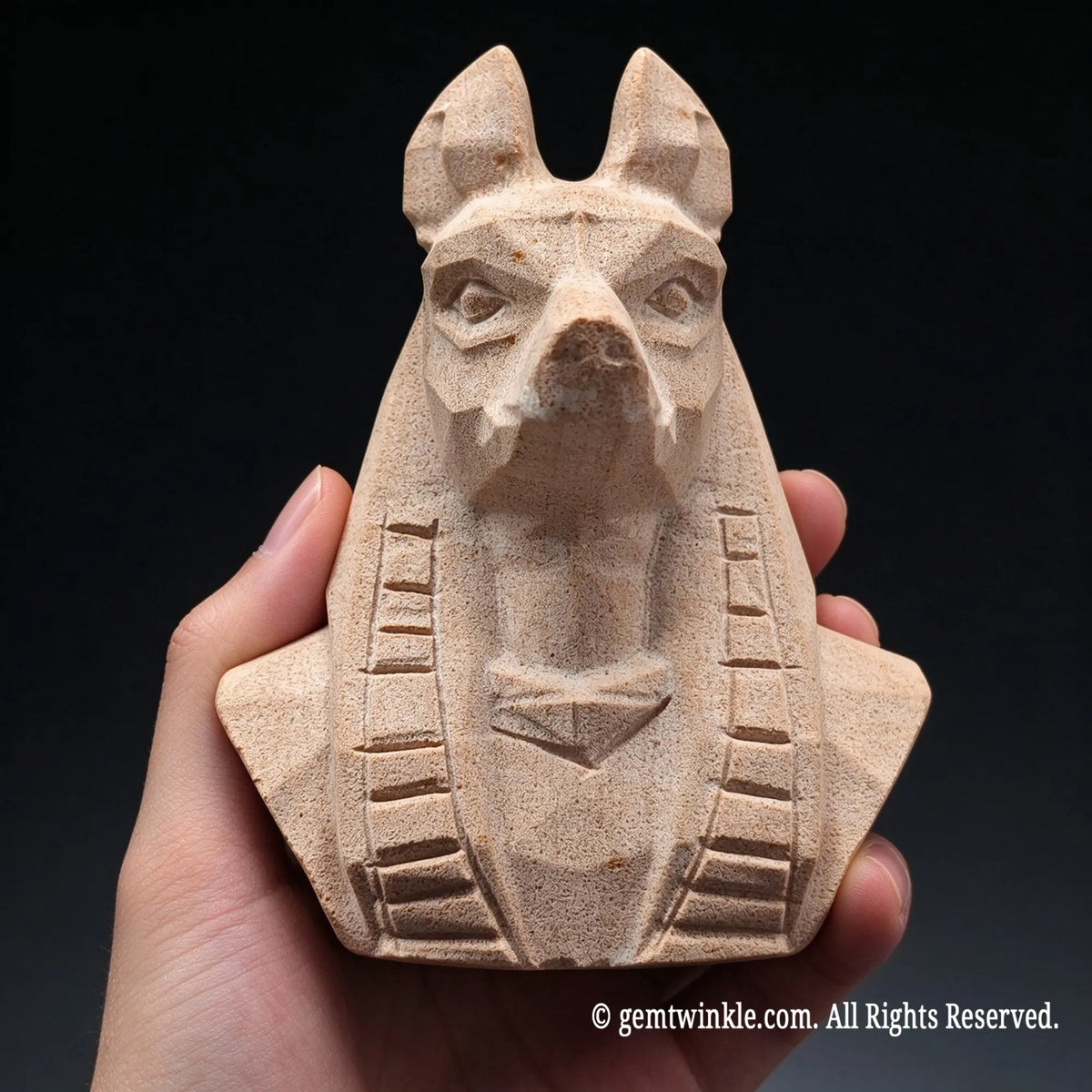 natural beige sandstone egyptian anubis bust statue held in hand displaying carved jackal head and nemes headcloth
