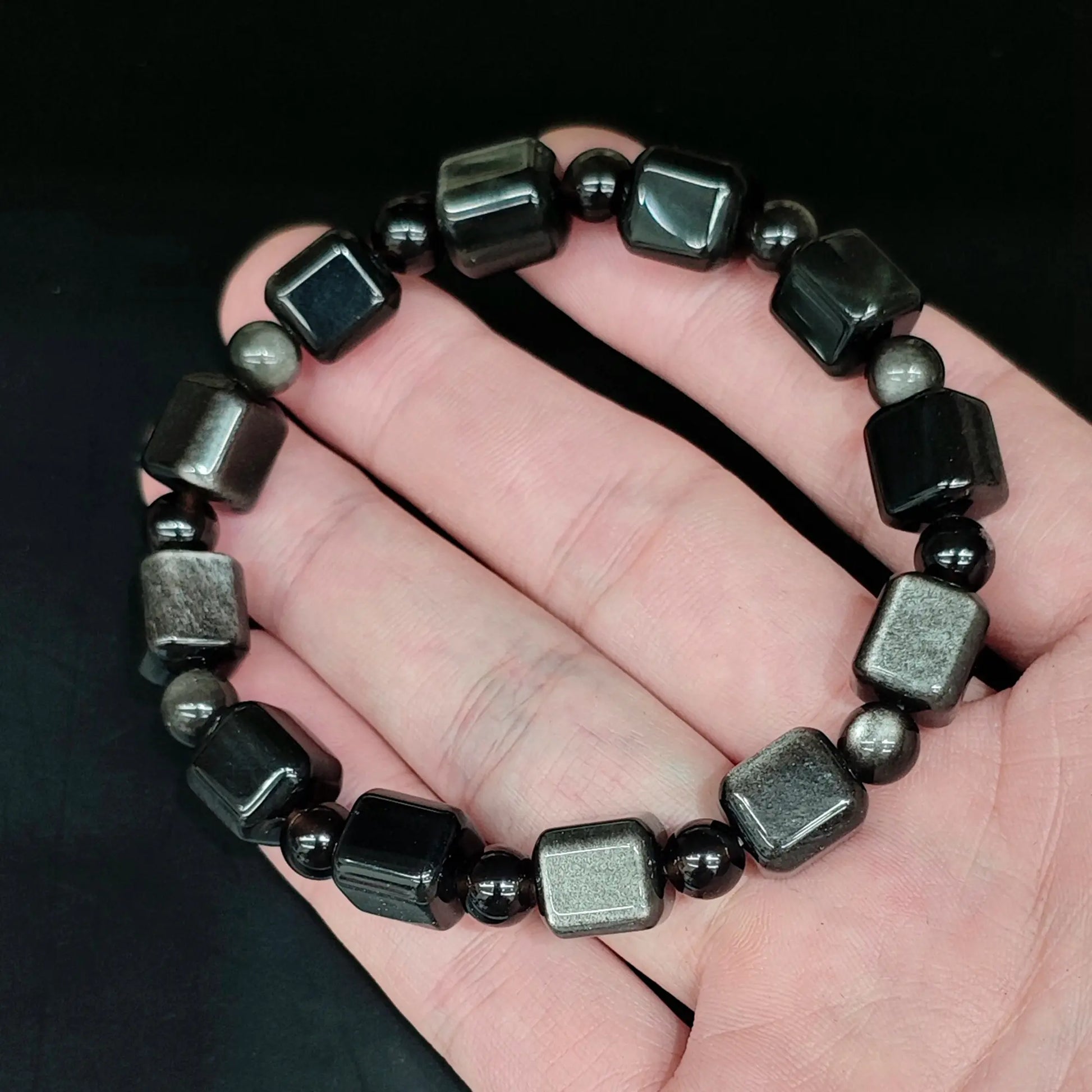 Natural silver sheen obsidian 10mm cube bead bracelet held close up showing bright silver sheen and smooth rounded edges