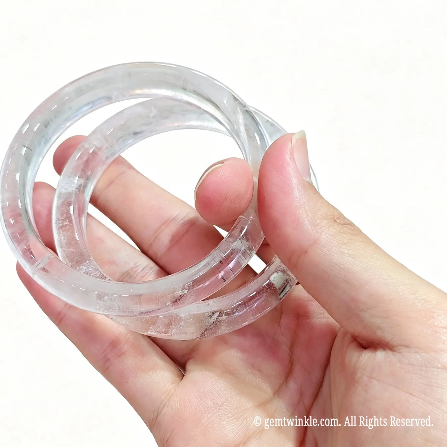 Two translucent natural clear quartz bangles held together for crystal boutique inventory