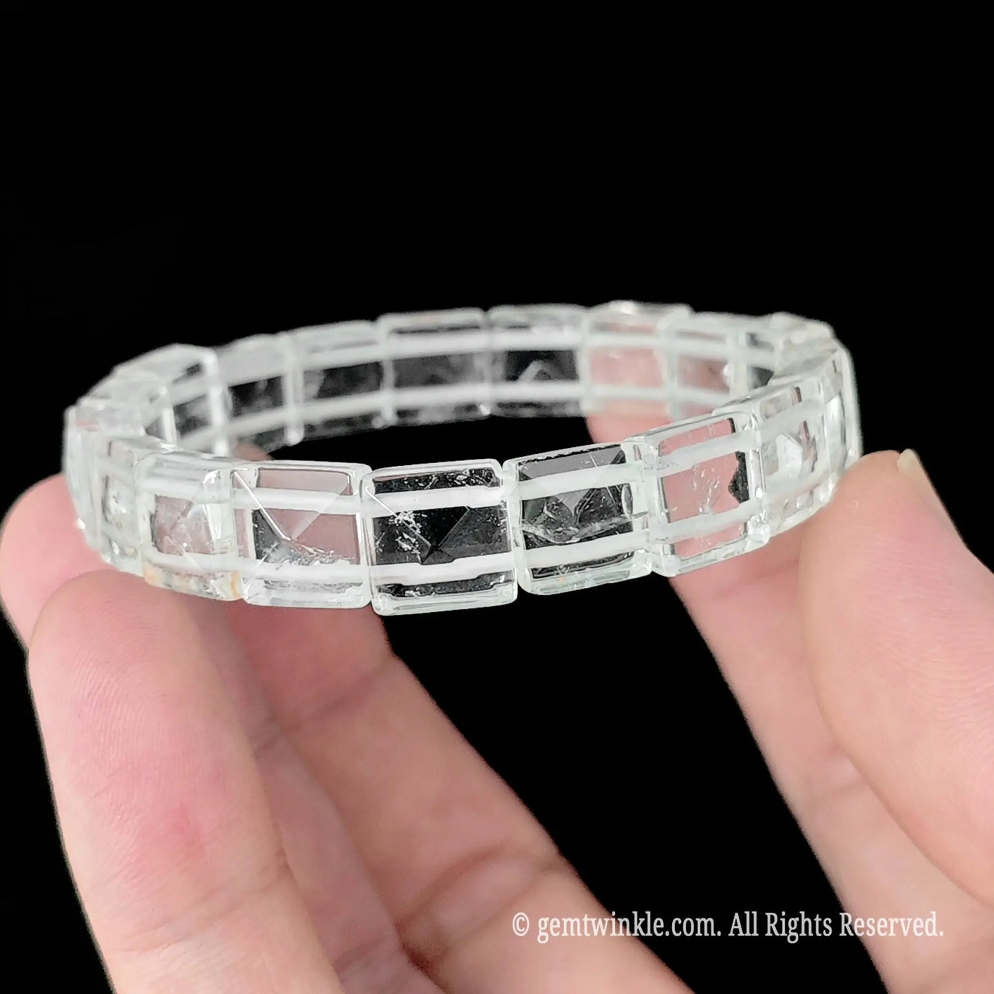 Natural white crystal pyramid stud square bead bracelet held horizontally showcasing uniform bead alignment